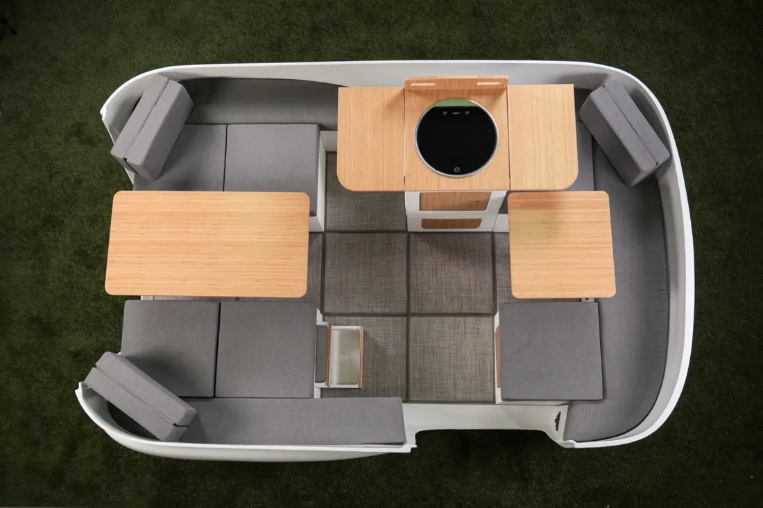 Overhead view of a furnished camper with cubes, cushions, and a kitchenette